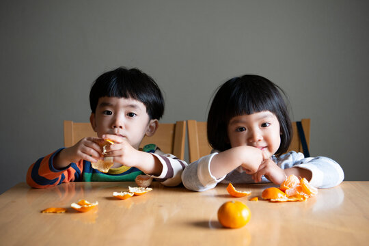 みかんを剥いている子供たち