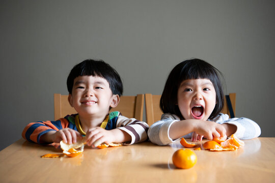 みかんを剥いて笑っている子供たち
