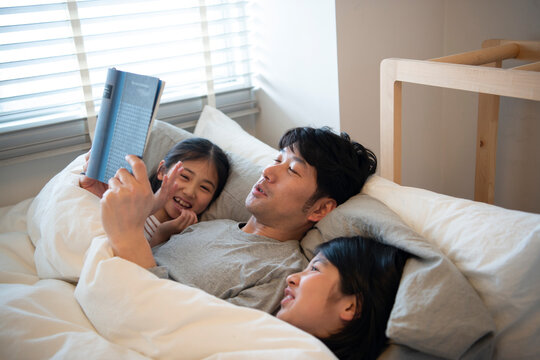 本を読んでいるお父さんと子供たち