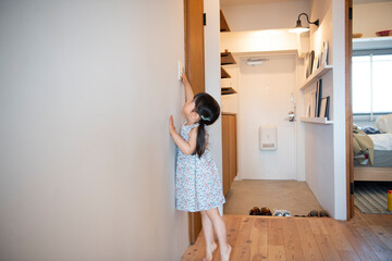 照明のスイッチを触っている女の子