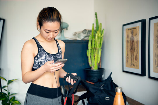ジムの待合スペースでスマホを見ている女性