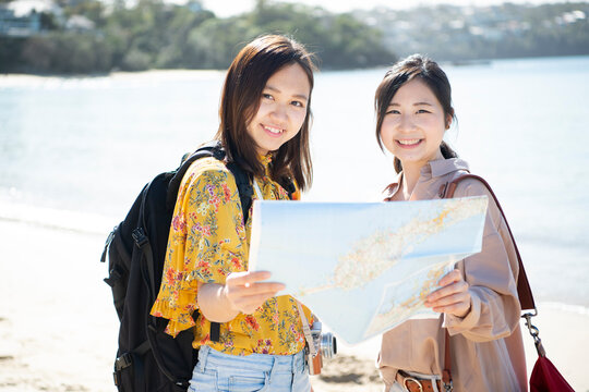 ビーチで地図を持っている女性2人