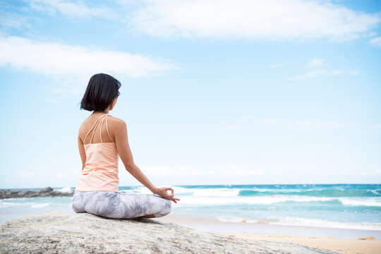 ビーチで瞑想をしている女性