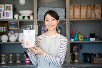 商品を持っている笑顔の女性店員