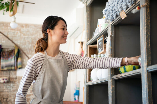 棚を整理している笑顔の女性店員