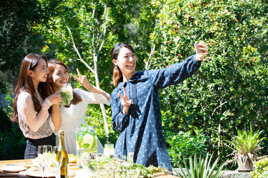 ガーデンパーティで自撮りをしている女性3人