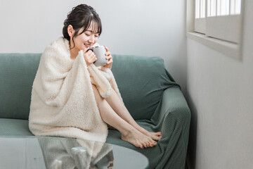 秋冬の寒い日にホットドリンクを飲むアジア人女性（カフェ・コーヒー）
