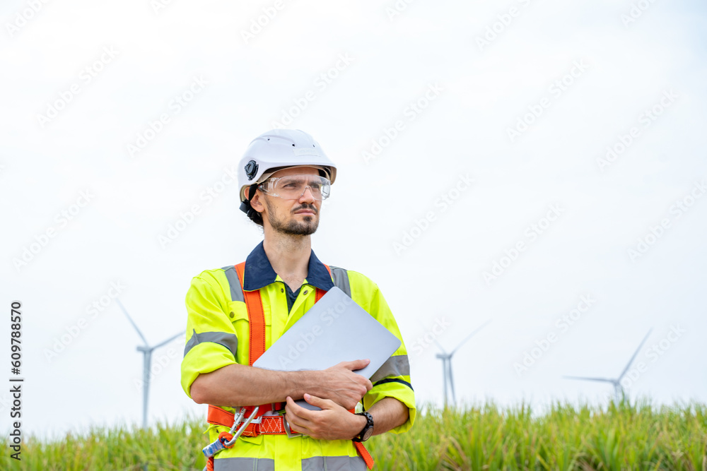 Poster Engineer man looking and checking wind turbines at field,Wind turbine farm generator by alternative green energy.