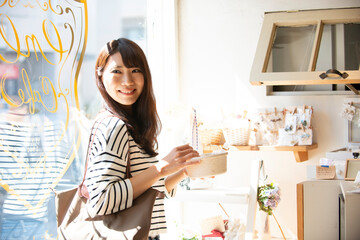 雑貨屋でアクセサリーを選んでいる女性