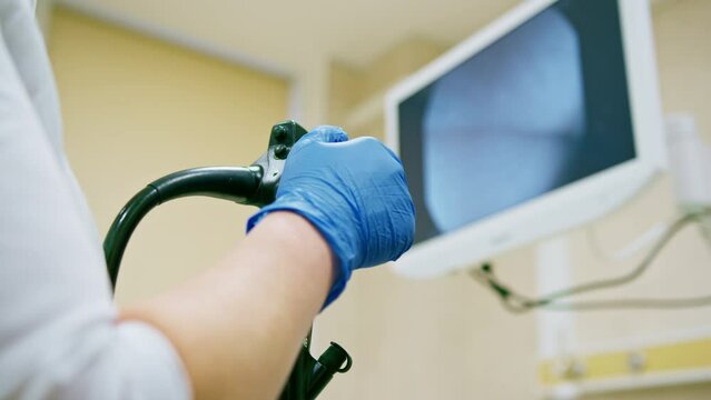 Close-up of doctor's gloved hand with endoscope during diagnostic gastroscopy or colonoscopy in clinic