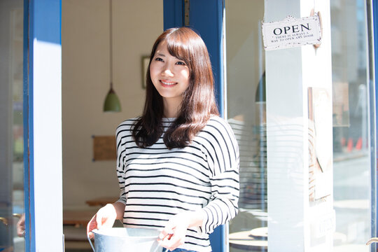 お店の前で笑っている女性