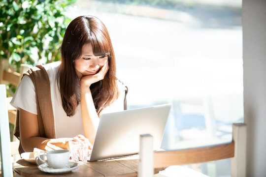 カフェでパソコンを使って仕事をしている女性