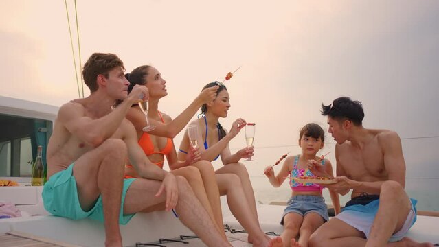 Group of diverse friends eating barbecue while having a party in yacht.