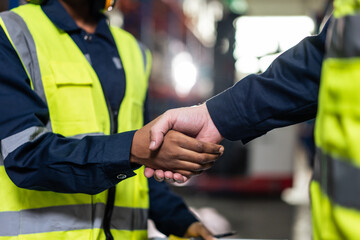 Close up of diverse industrial worker doing handshake in manufactory. 