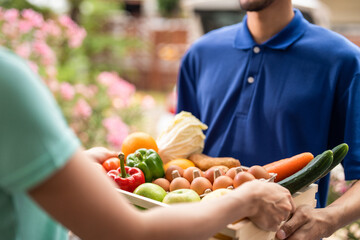 Close up hands of young delivery man delivering package to customer. 