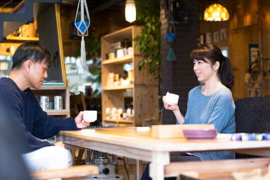 カフェでコーヒーを飲みながら話しをする夫婦
