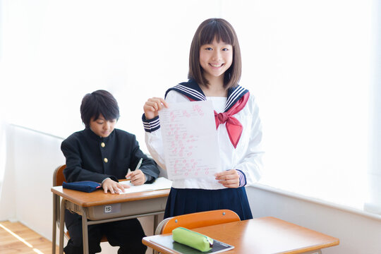 満点のテストを掲げる中学生