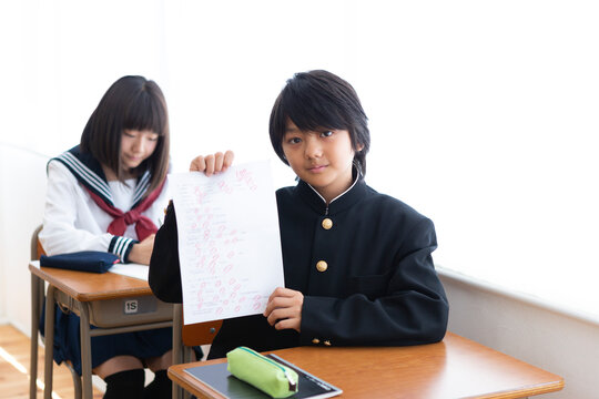 満点のテストを掲げる中学生