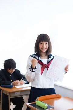 満点のテストを掲げる中学生