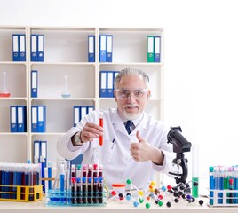 Old male chemist working in the lab