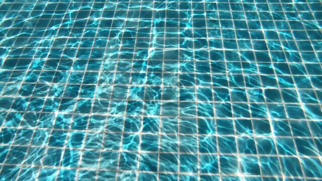 diving into the water on blue swimming pool, beautiful pool texture background, slow motion scene