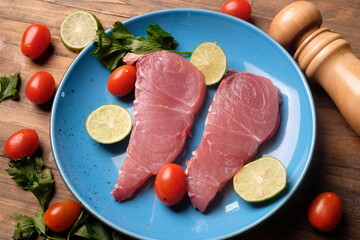 fish fillet on blue ceramic plate. fillet is fish meat that has been cut or sliced away from the bone by cutting lengthwise along one side of the fish parallel to the spine. Istiompax indica. Marlin

