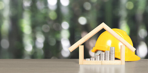 Yellow hardhat model house and coin with trading graph