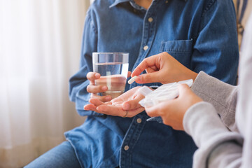 Closeup image of a woman holding and giving pills to her friend