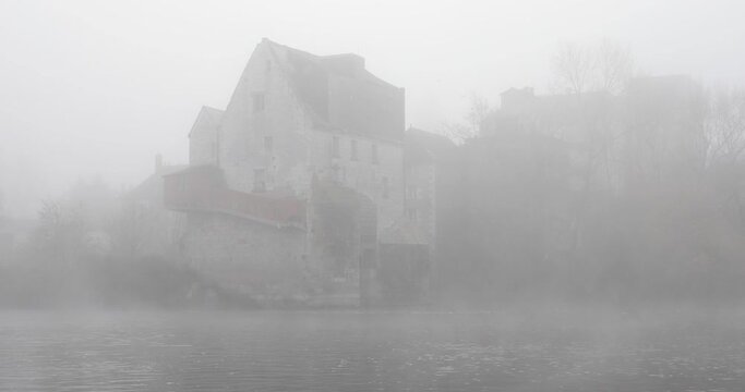 Grand Moulin de Ballan-Mire on a foggy morning on the river Cher near to Tours, France. Constructed in 1520, the Big Mill at Ballan Mire is a classified monument.