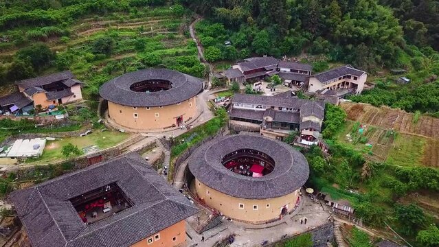 Drone shot flying towards traditional Tulou Hakka Round Houses in Fujian, China