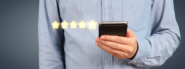 Man holding smartphone device and touching screen with five star rating
