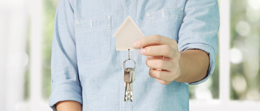 Real estate agent handing over  house keys in hand