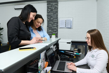 Female doctor and patient discussing medical treatment needs to perform, filling out and signing...