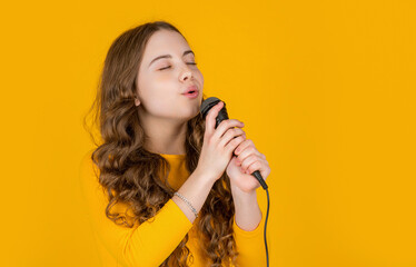 musical teen girl with microphone on yellow background