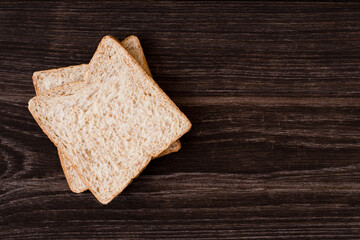 Fresh wheat bread slice on wooden table background. Top view. Flat lay.