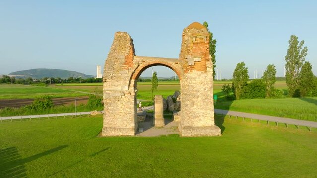 Antique View Of Heidentor's Remaining Arch And Column During Daytime In Petronell-Carnuntum, Austria. aerial pull-back