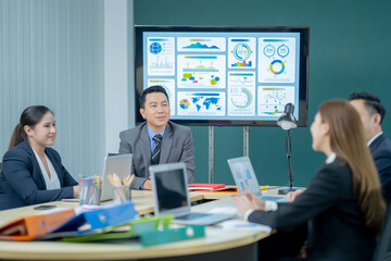 Office Conference Room Meeting Presentation: asian Businessman Talks, Uses Wall TV to Show Company Growth with Big Data Analysis, Graphs, Charts, Infographics. Multi-Ethnic e-Commerce Startup 