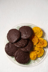 Round cookies in chocolate with cinnamon and candied pineapple, top view