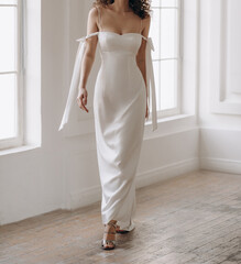 Gorgeous wedding dress with cleavage and stylish bows on the arms. Beautiful bride in the white wedding dress.