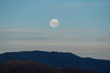 Full moon in a New Zealand landscape at sunset