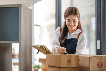 Startup small business entrepreneur SME, asian woman packing cloth in box. Portrait young Asian small business owner home office, online sell marketing delivery, SME e-commerce telemarketing concept.