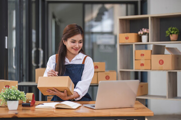 Portrait business woman smile and use tablet checking information on parcel shipping box before send to customer. Entrepreneur small business working at home. SME business online marketing.