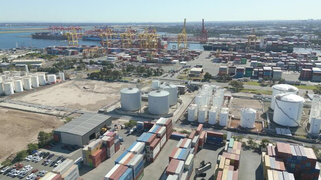 Stacked cargo containers at Port Botany terminal, global logistics ready for shipping at Botany Bay, NSW. Pan left Aerial establishing shot.