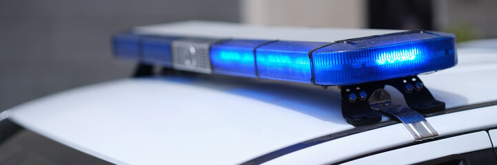 Closeup of blue lights on roof of police car. Flashing beacons of police car and arrest of criminal © H_Ko