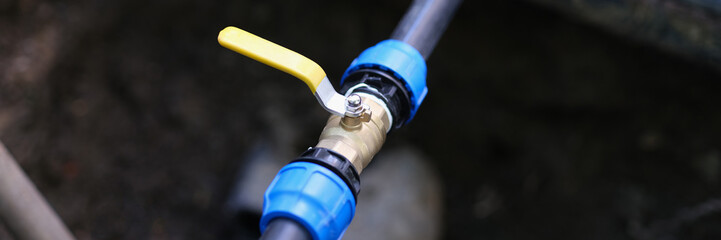 Naklejka premium Pvc pipes with tap in ground on garden plot. Installation of underground irrigation system and drainage of tap water