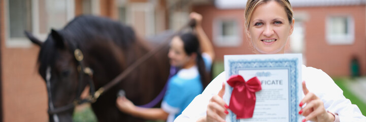Woman veterinarian holds medical certificate for horse. Medical examination of sports purebred horses