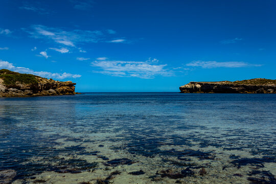 The bay at Pondalowie, Innes National Park with the sea flanked by two cliffs on a bright blue sky day.