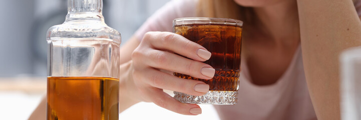 Drunk woman holding glass of whiskey and alcoholics alone. Unhappy woman suffering from migraine...