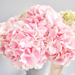Beautiful pink hydrangea flowers in a vase on a table . Bouquet of light pink flower. Decoration of home. Wallpaper and background. fuchsia color