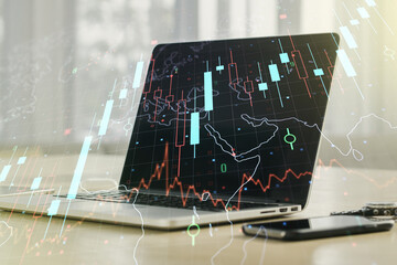 Multi exposure of abstract creative financial chart with world map on laptop background, research and analytics concept